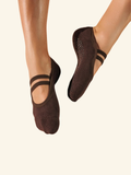 Brown ballet flats worn by a person on a beige background