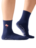 Navy blue socks with a floral design and white grip dots on a transparent background