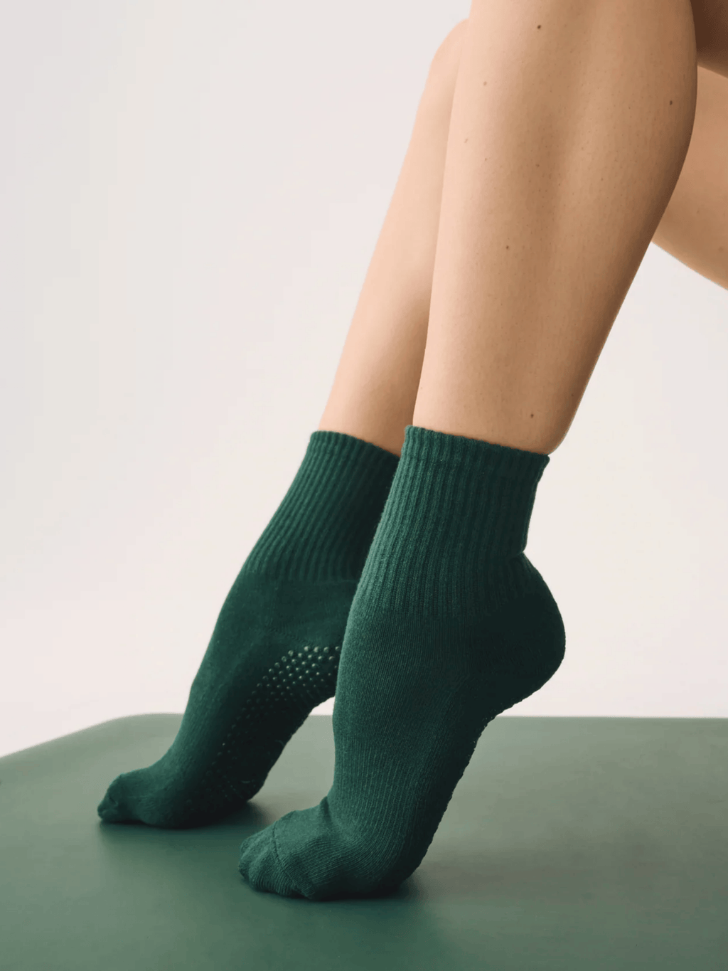 Person wearing green socks on a plain background
