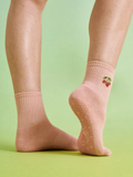 Pink socks with a floral design on a light green background