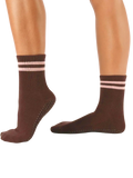 Brown socks with pink stripes worn by a person on a white background