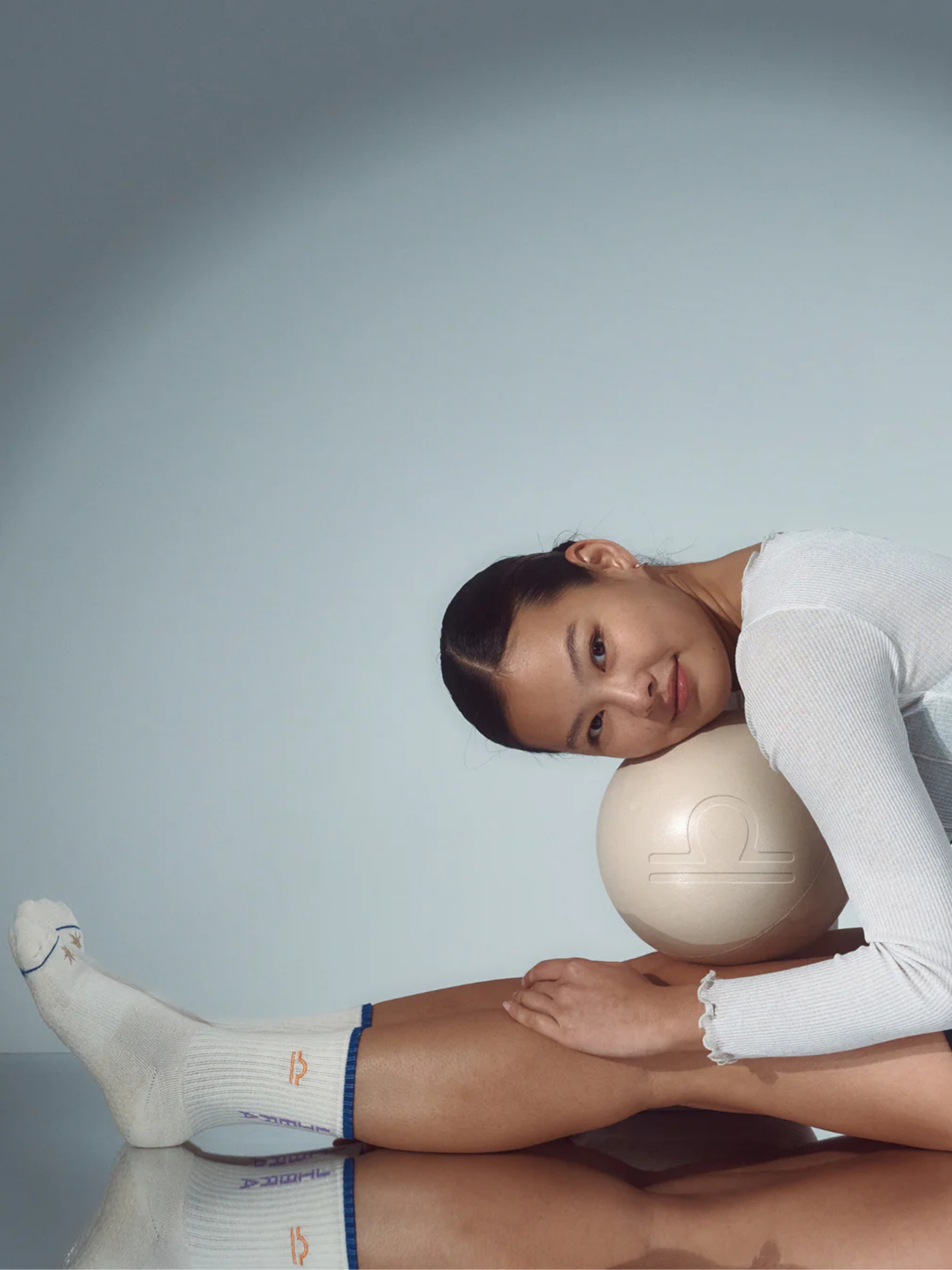 Person with a ball under their head against a plain background
