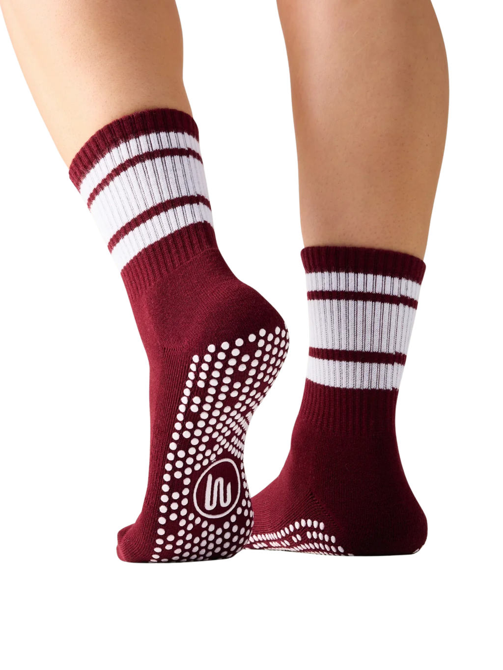 Maroon socks with white stripes and non-slip grip on toes worn by a person on a white background