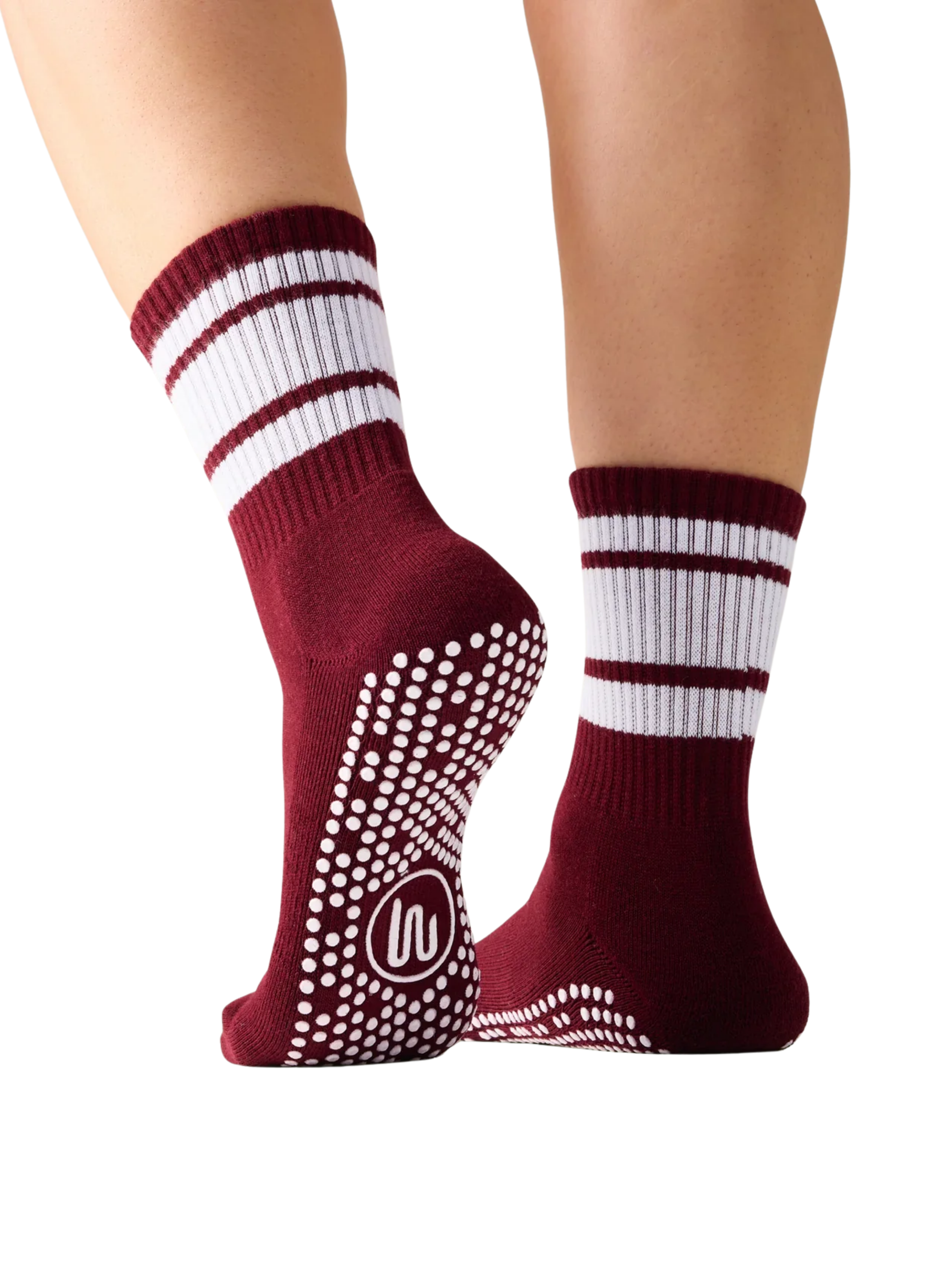Maroon socks with white stripes and non-slip grip on toes worn by a person on a white background