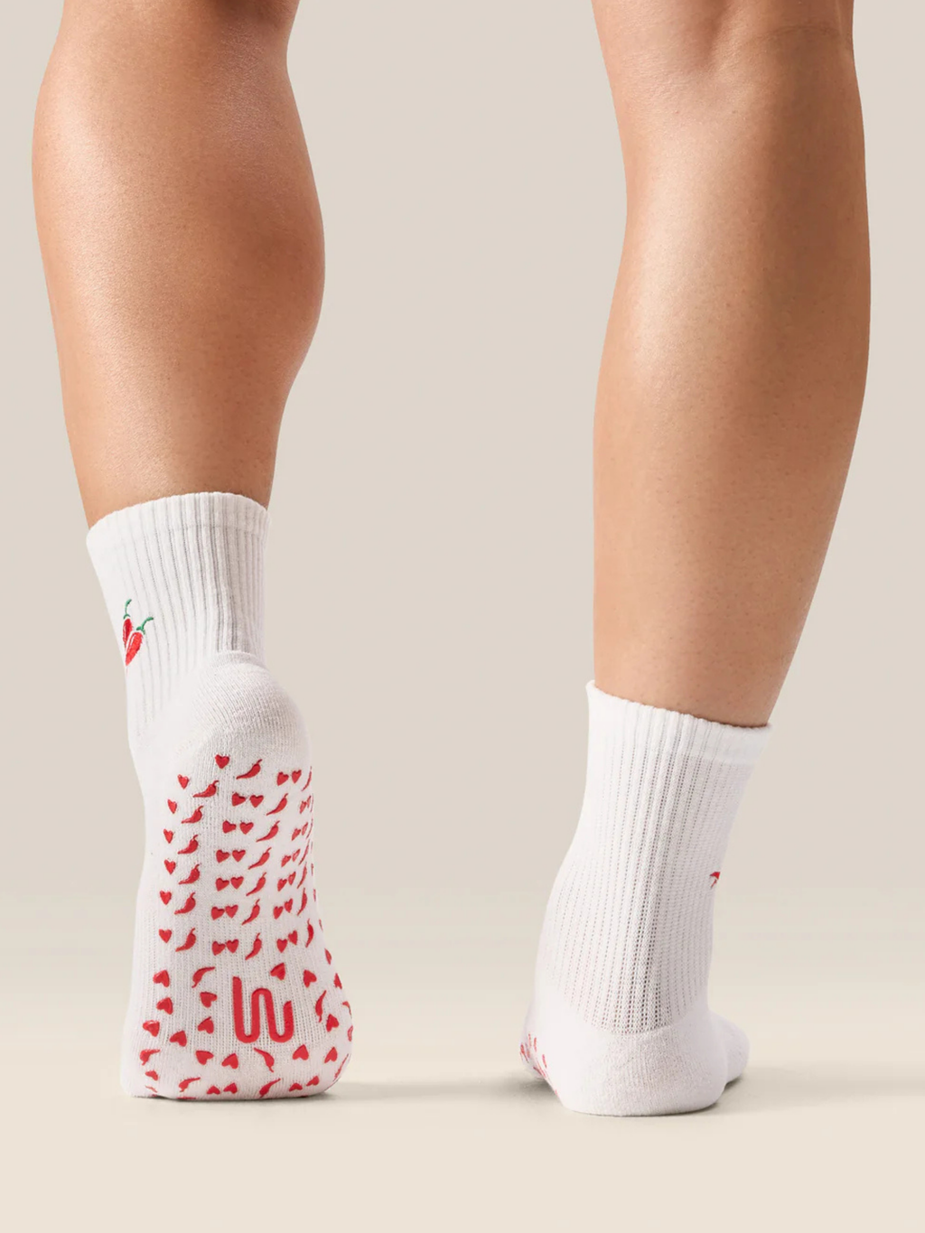 White socks with red pattern worn by a person on a neutral background
