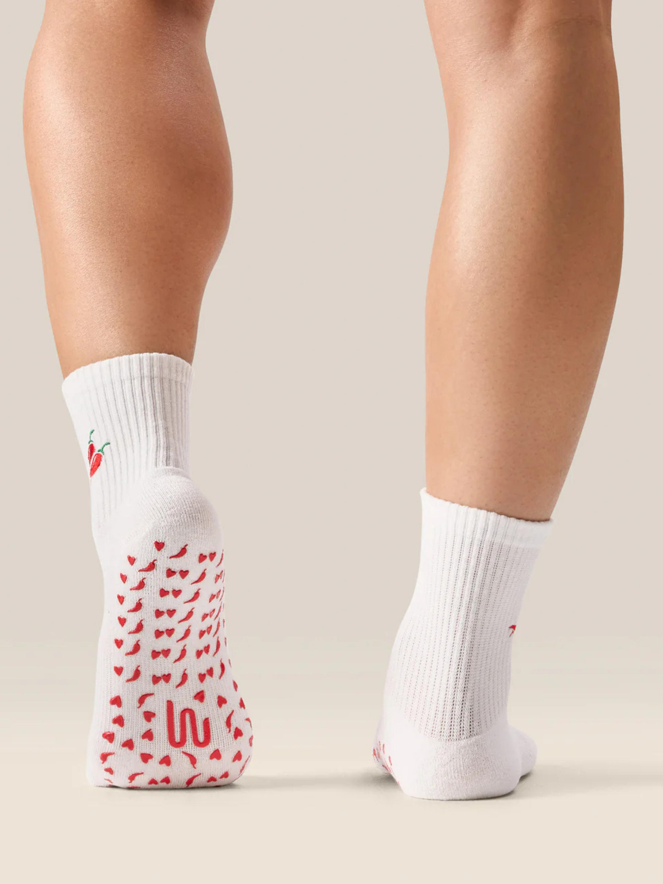 White socks with red pattern worn by a person on a neutral background