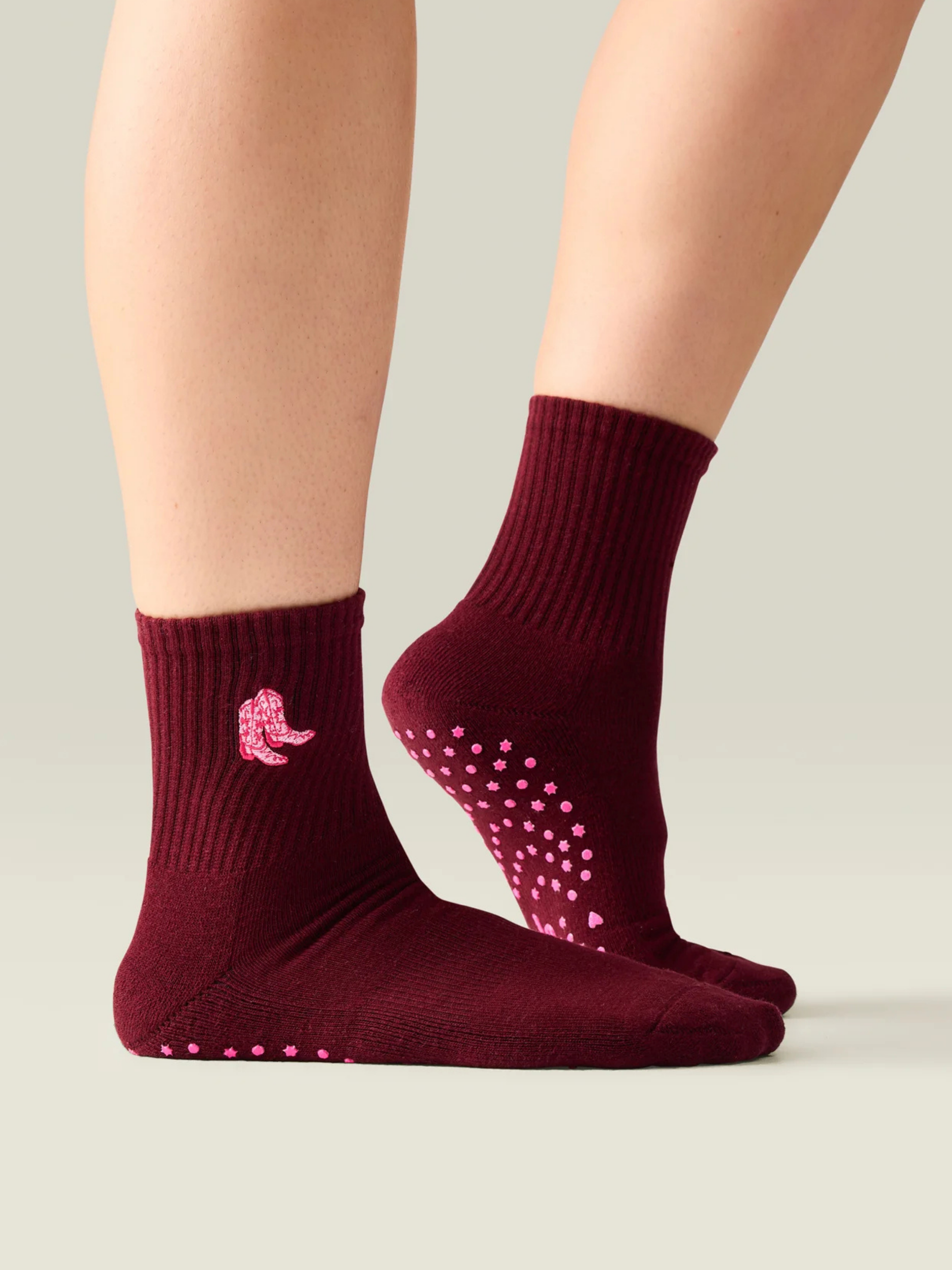 Burgundy socks with pink butterfly design and pink dots on a neutral background