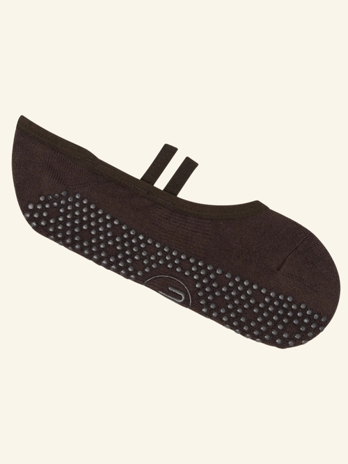 Brown foot care product with textured sole on a beige background