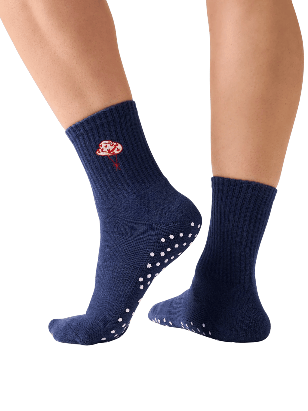Navy blue socks with white grip dots worn by a person on a transparent background