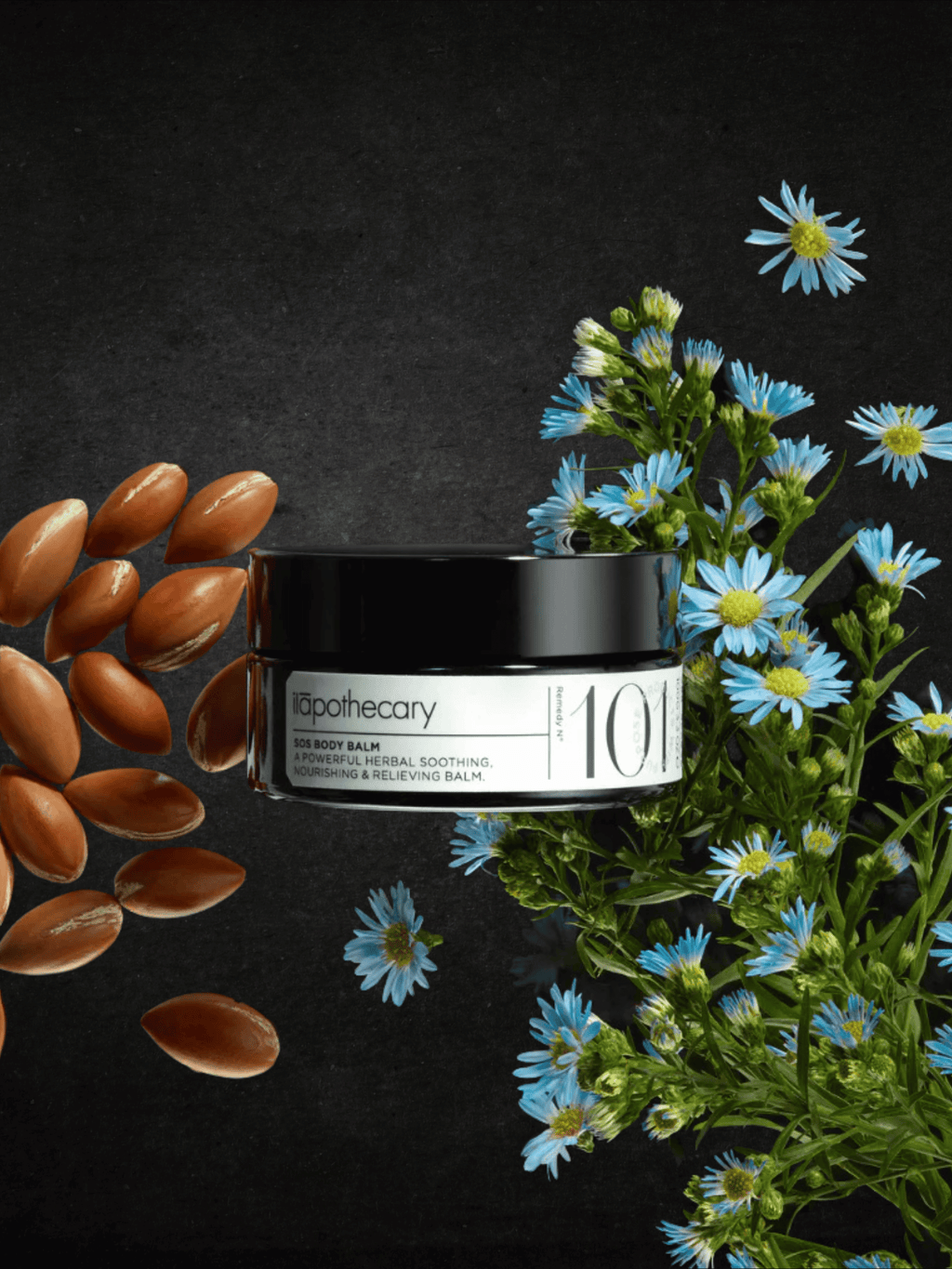 101 SOS body balm jar with almonds and flowers on a dark background