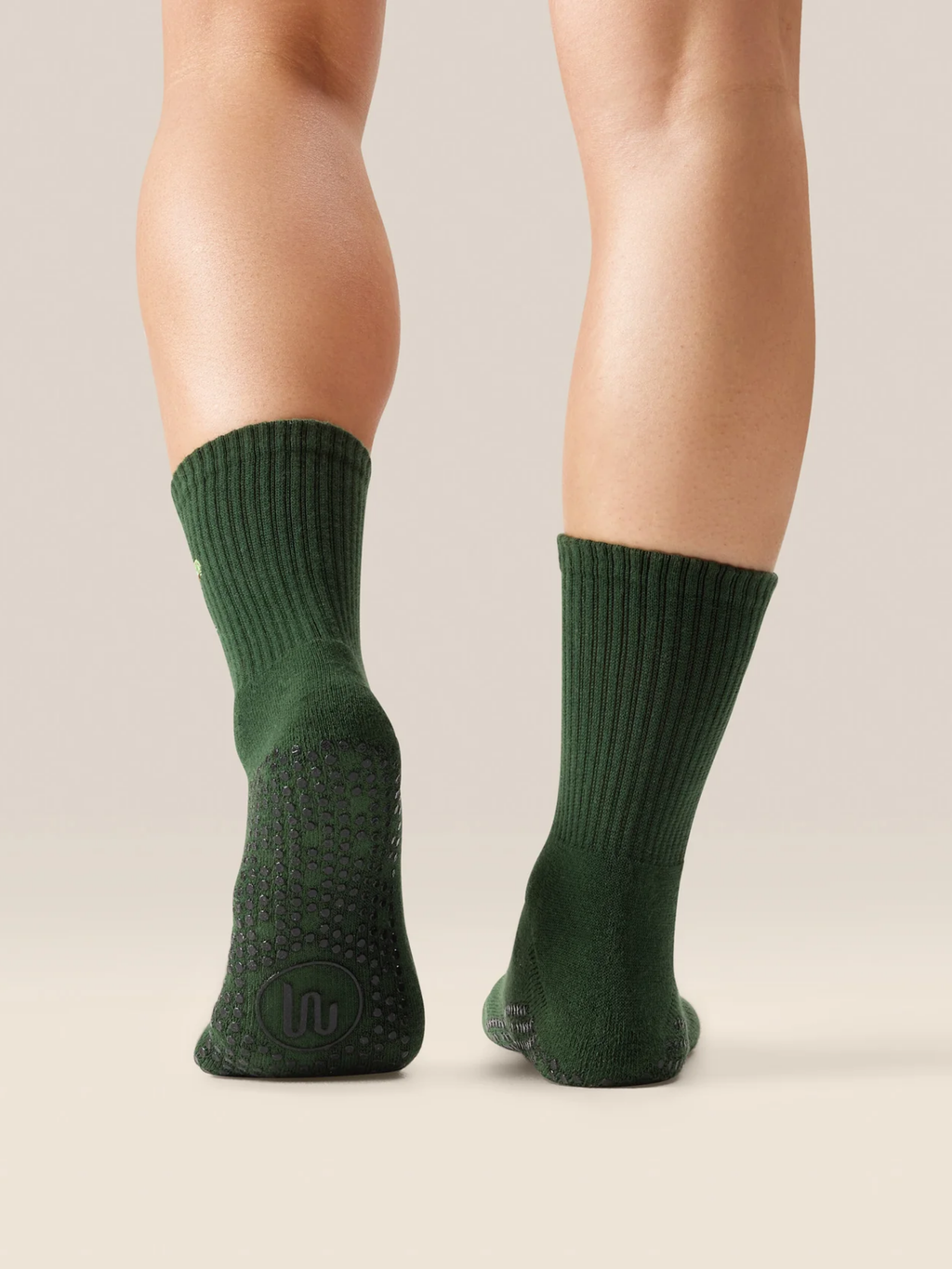 Green socks worn by a person on a neutral background
