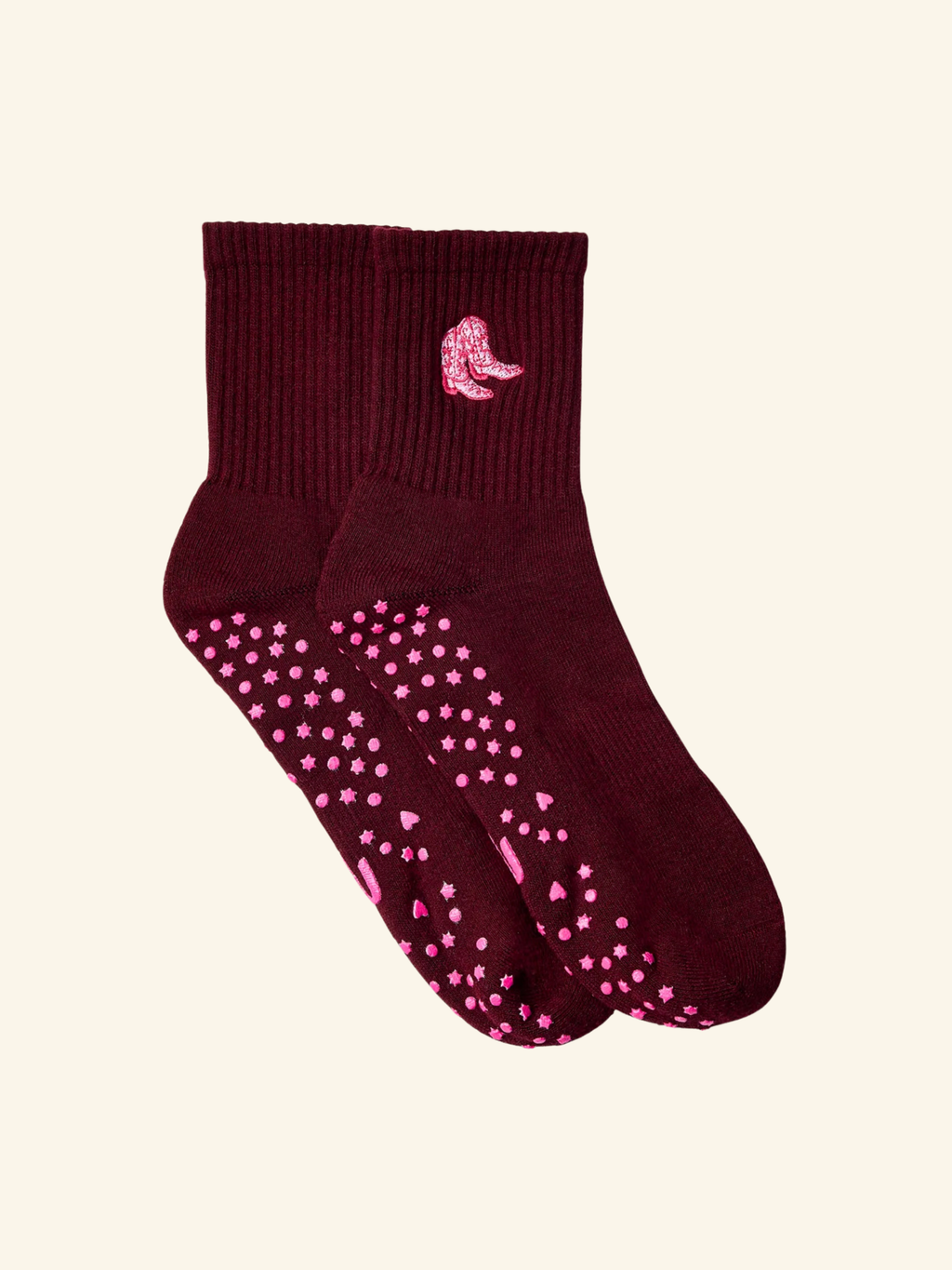 Maroon sock with pink polka dots and a small pink logo on a beige background