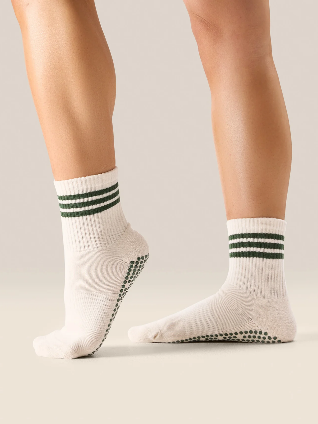 White socks with green stripes and black dots on a neutral background