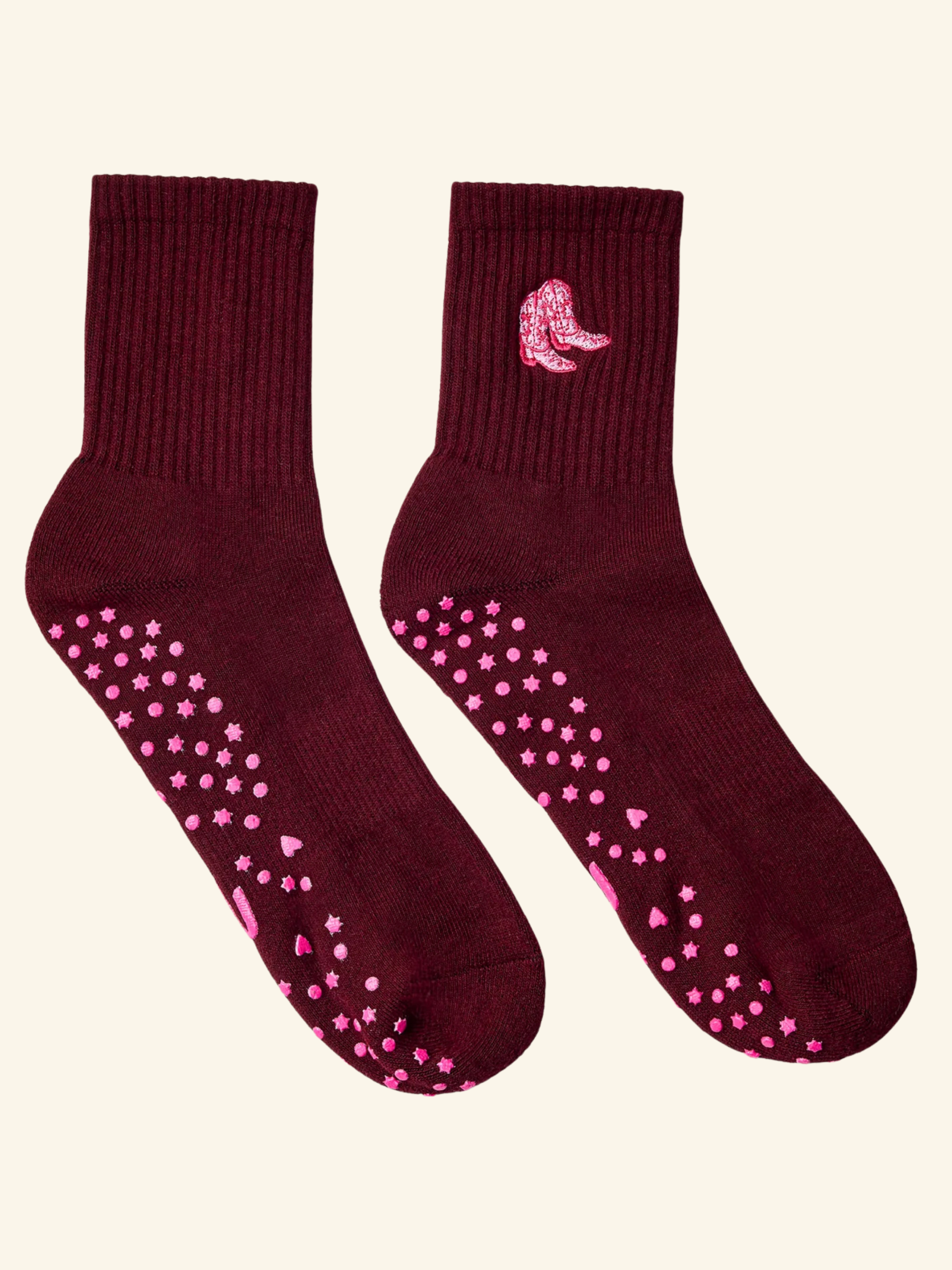 Maroon socks with pink slip-resistant dots on a beige background