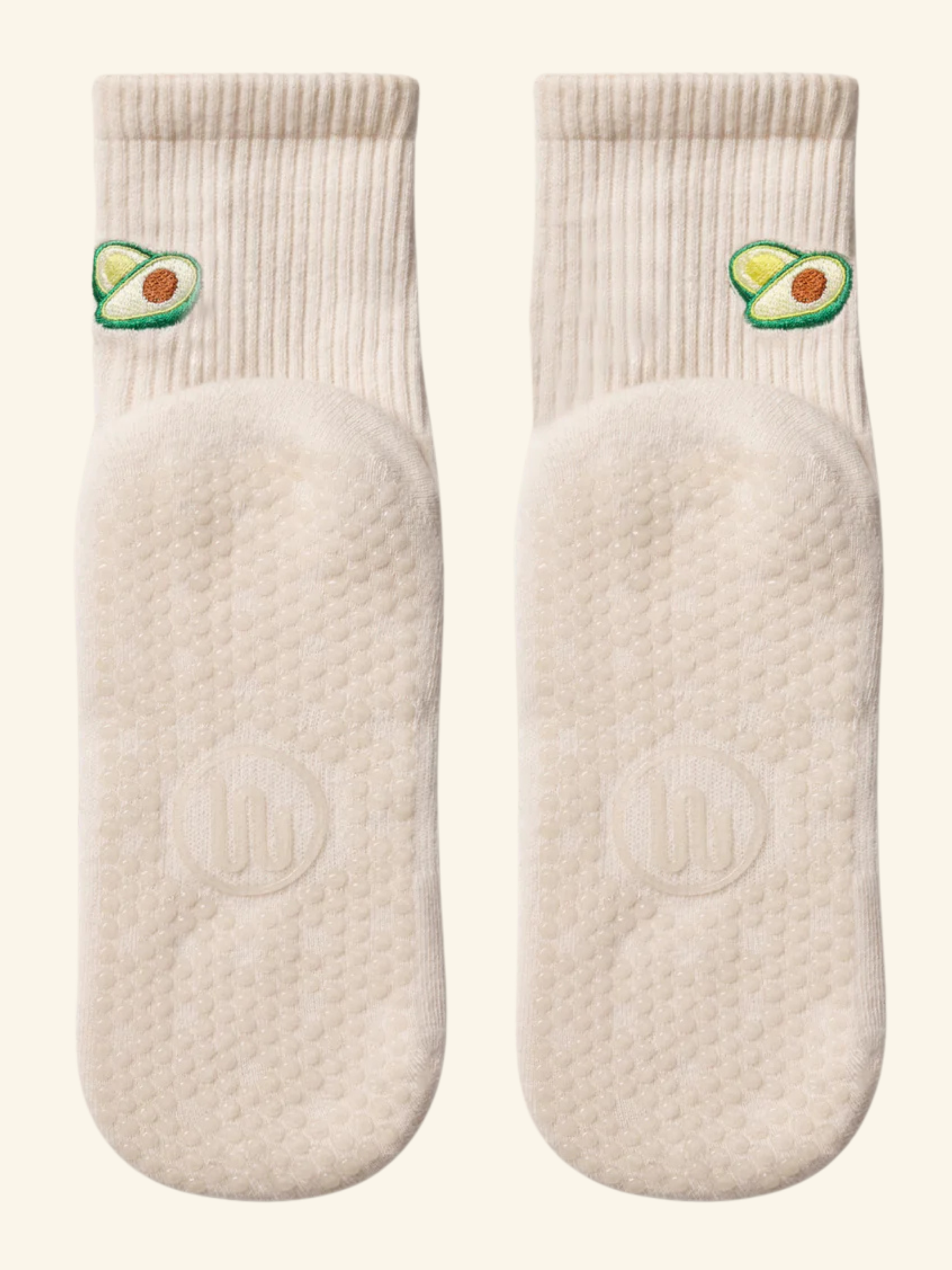 Pair of white socks with avocado design on a white background