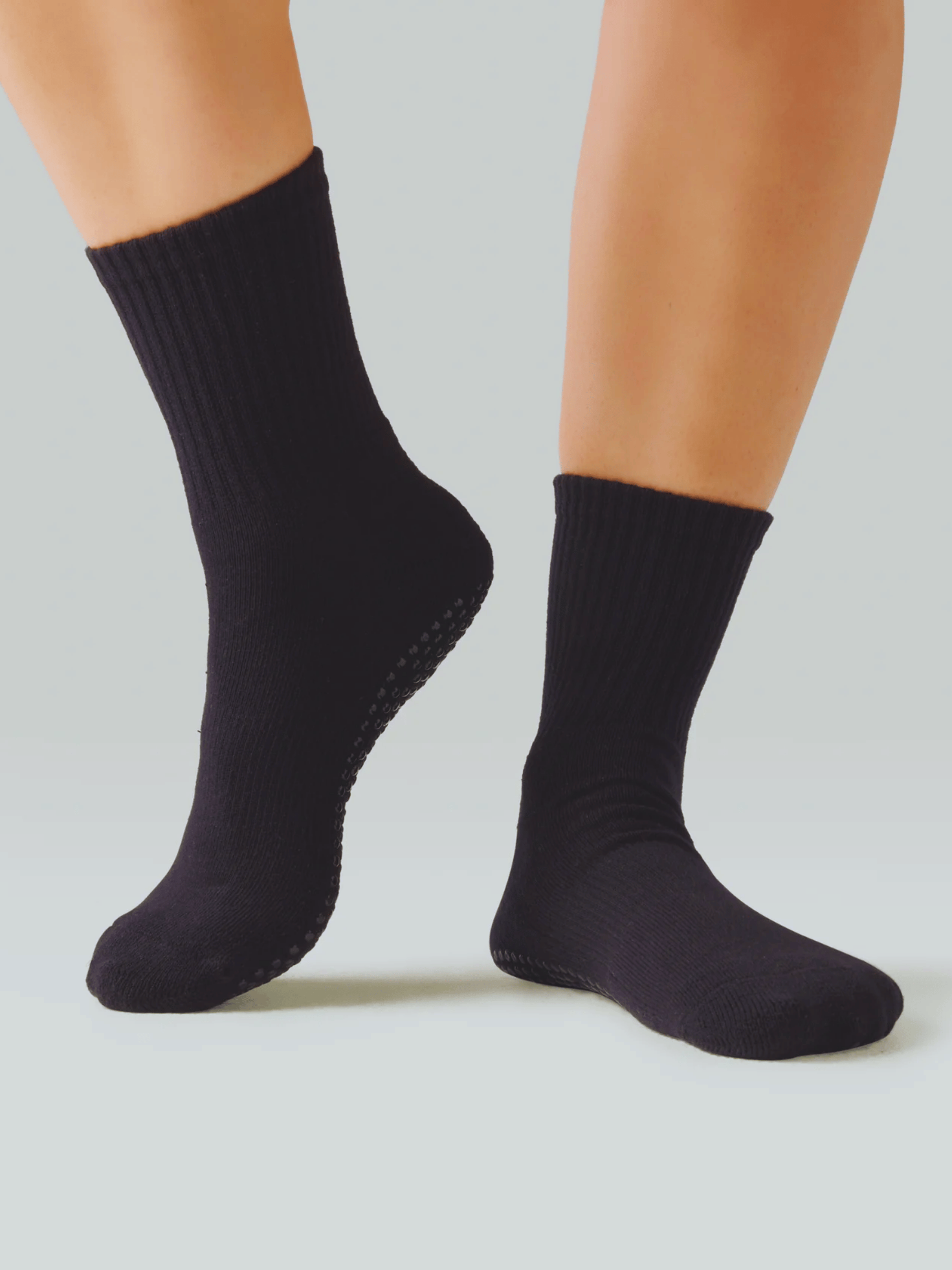 Black socks worn on a light gray background