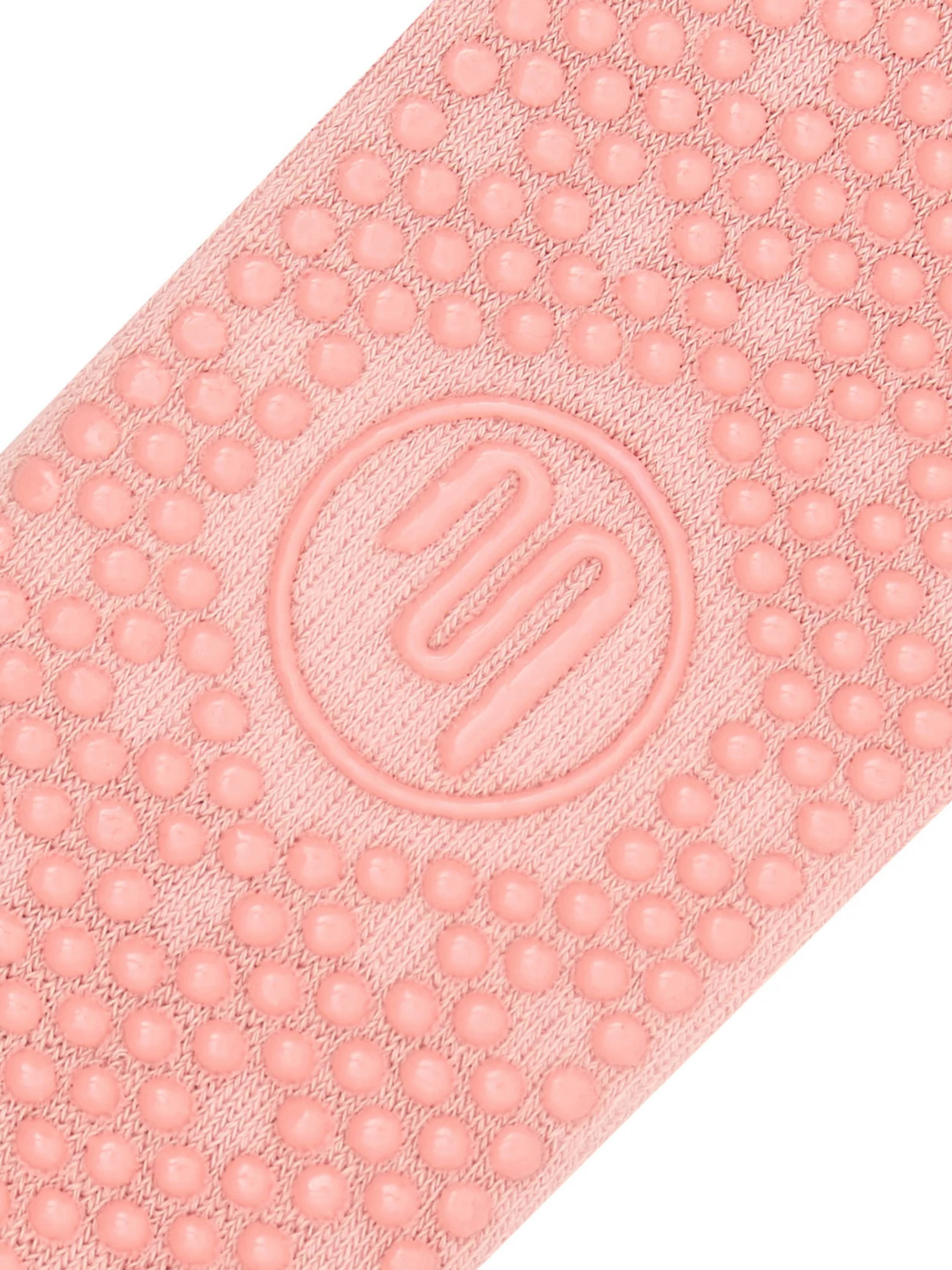 Close-up of a pink textured mat with a logo in the center on a white background