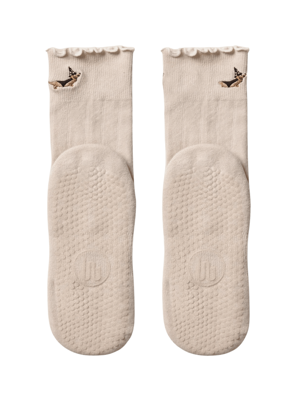 Pair of light pink socks with textured sole on a green background