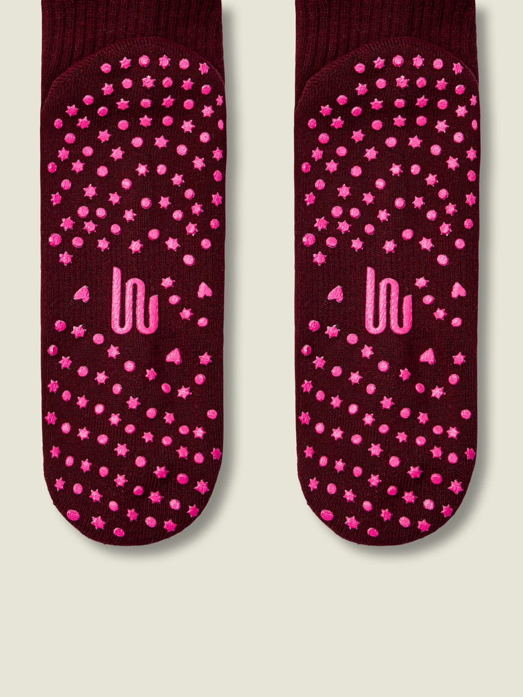 Maroon socks with pink star patterns and 'UU' logo on a beige background