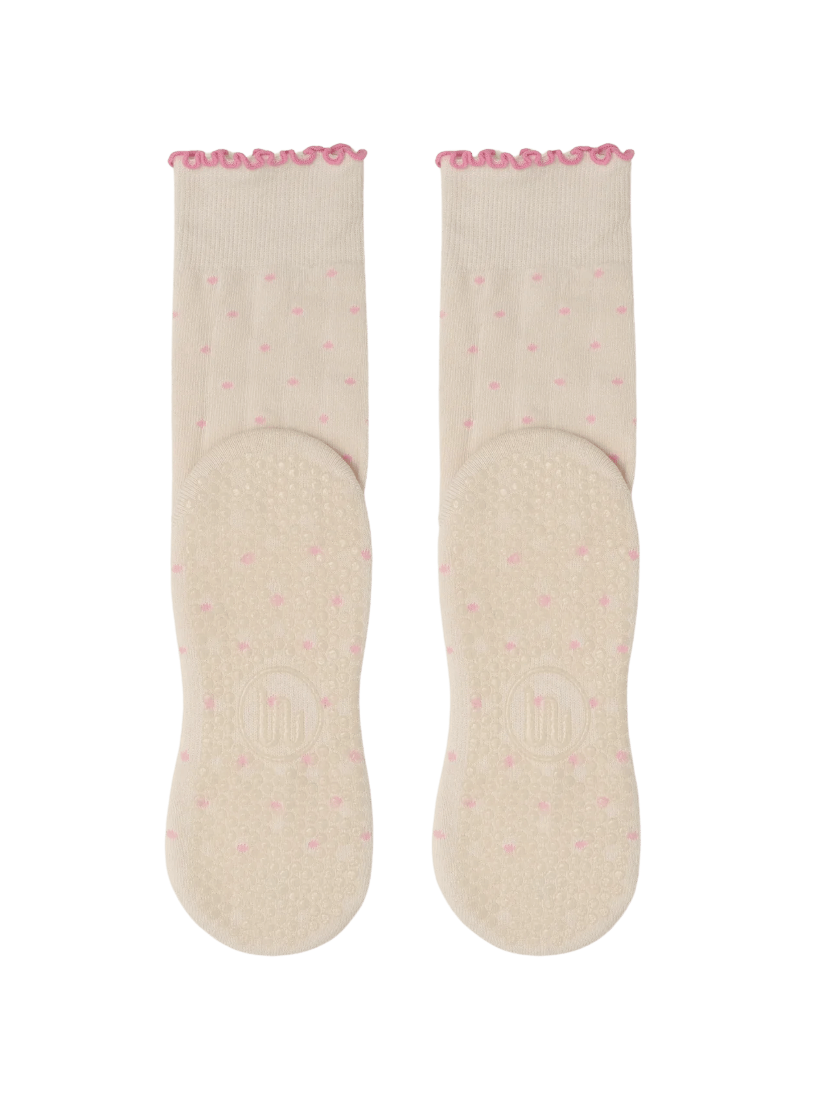 Pair of light pink socks with a subtle pattern on a green background