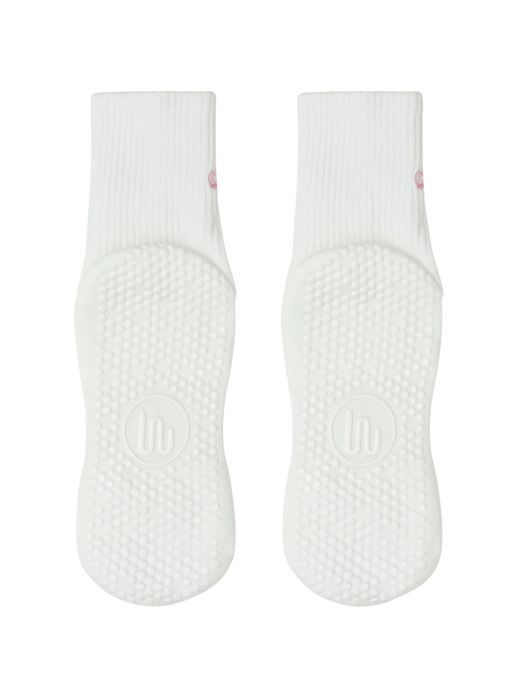 Pair of white baby socks with textured sole on a green background