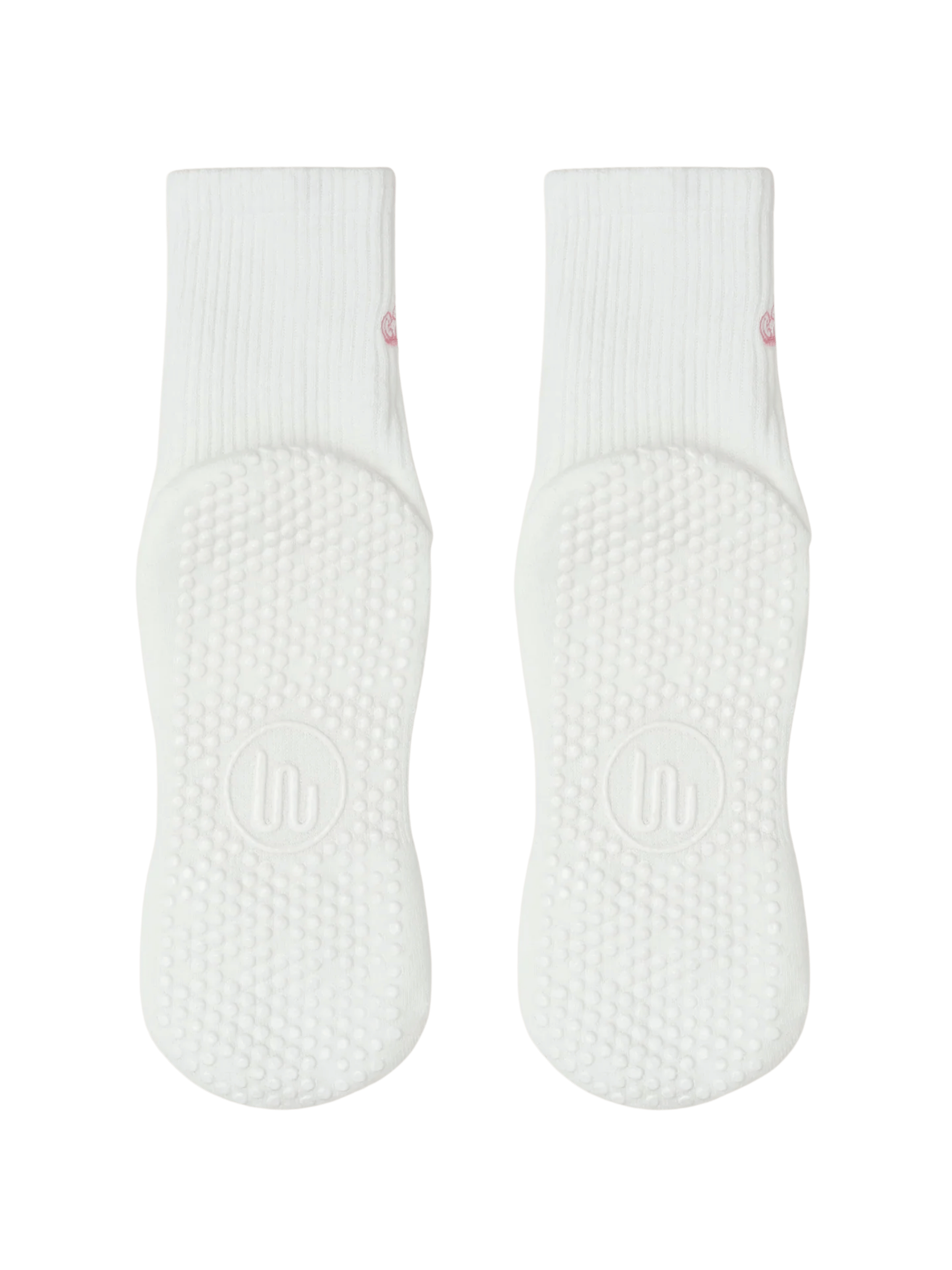 Pair of white baby socks with textured sole on a green background