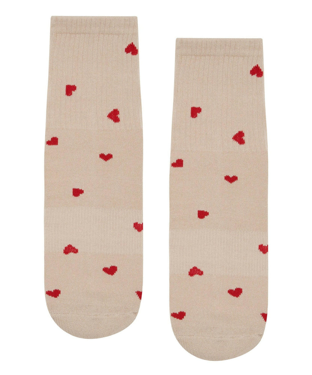 Beige socks with red heart patterns on a white background