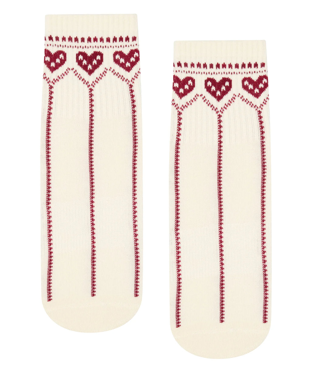 Pair of cream socks with red heart patterns on a white background